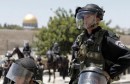 Israeli security looks on as Palestinian Muslim worshipers (unseen) perform traditional Friday noon prayers along a street outside the Old City in East Jerusalem, on July 11, 2014, on the second Friday of Islam's holy month of Ramadan. Israeli authority has forbidden access to Al-Aqsa mosque to Muslim men under 50-years-old. The Dome of the Rock mosque, part of the Al-Aqsa mosque compound, is seen in the background.  AFP PHOTO / AHMAD GHARABLI        (Photo credit should read AHMAD GHARABLI/AFP/Getty Images)