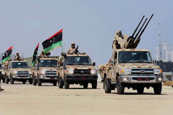 Soldiers of the Libyan National Army parade with their military pick-up vehicles during the graduation ceremony of new batch of the Libyan Navy special forces in the Mediterranean sea port of Tripoli, on July 3, 2012. AFP PHOTO/MAHMUD TURKIA        (Photo credit should read MAHMUD TURKIA/AFP/GettyImages)